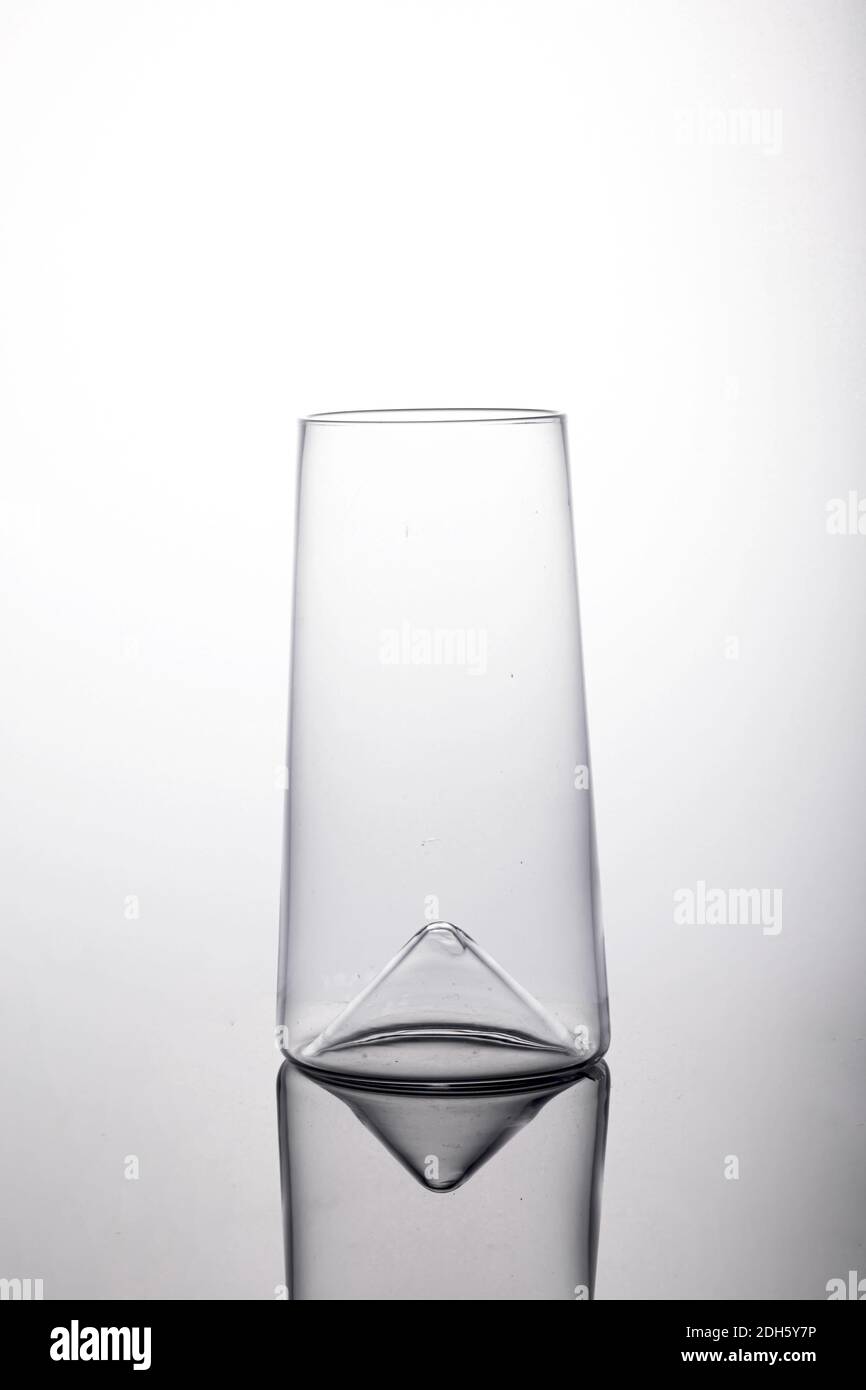 Un cliché vertical d'un verre à bille haute vide avec un fond concave sur la surface blanche avec une ombre Banque D'Images