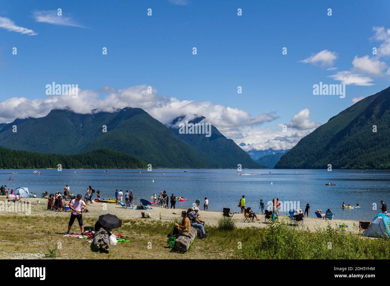 MAPLE RIDGE, CANADA - le 28 JUIN 2020 : plage pleine de gens au fond des montagnes et du ciel bleu du lac Alouette. Banque D'Images