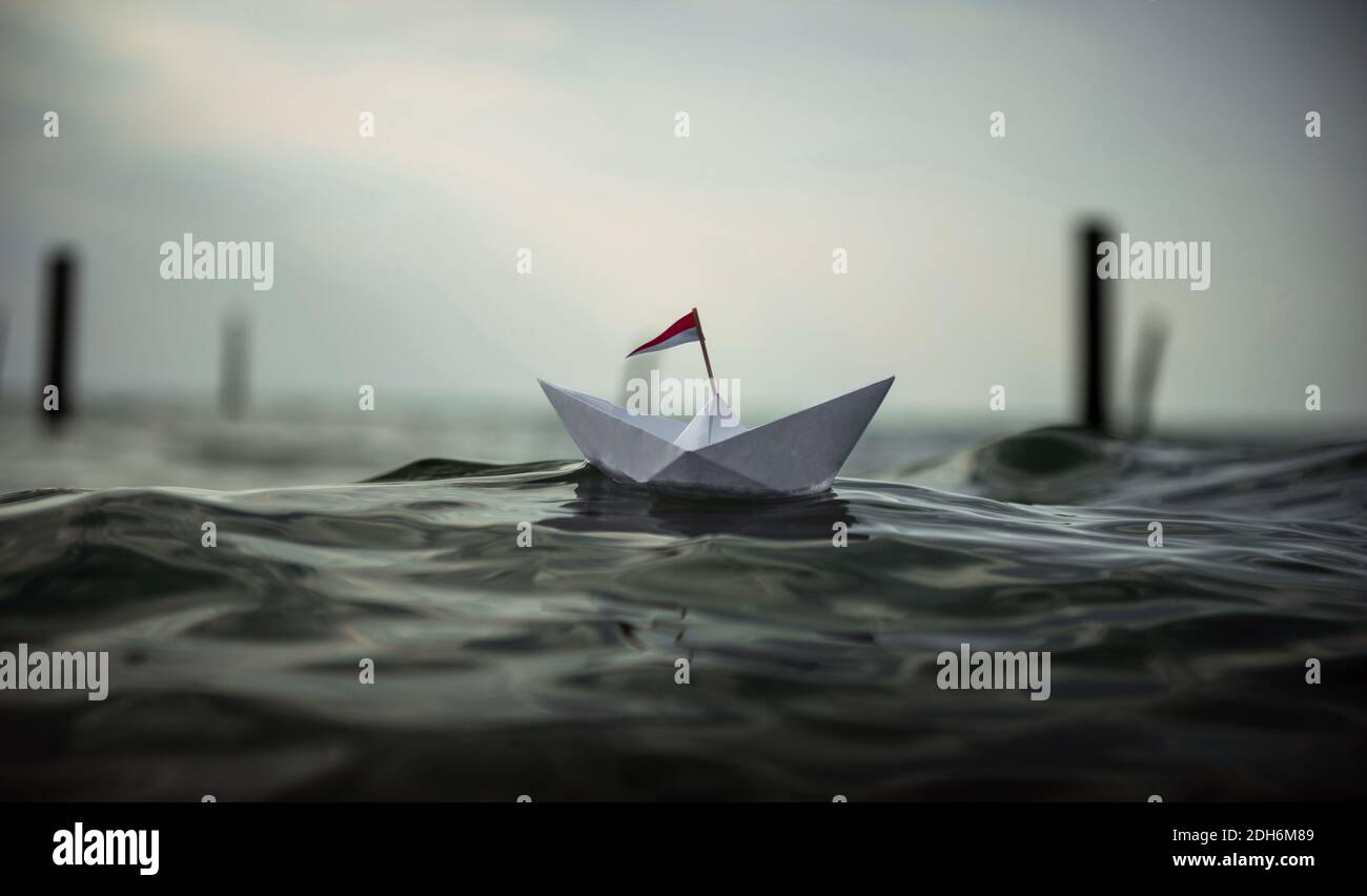 Bateau en papier dans les grandes vagues Banque D'Images