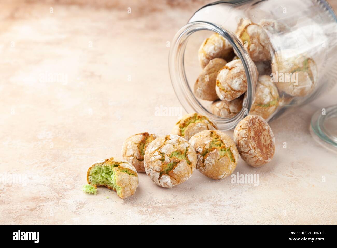 Délicieux biscuits ronds avec pistache, dispersés dans une banque en verre transparent Banque D'Images