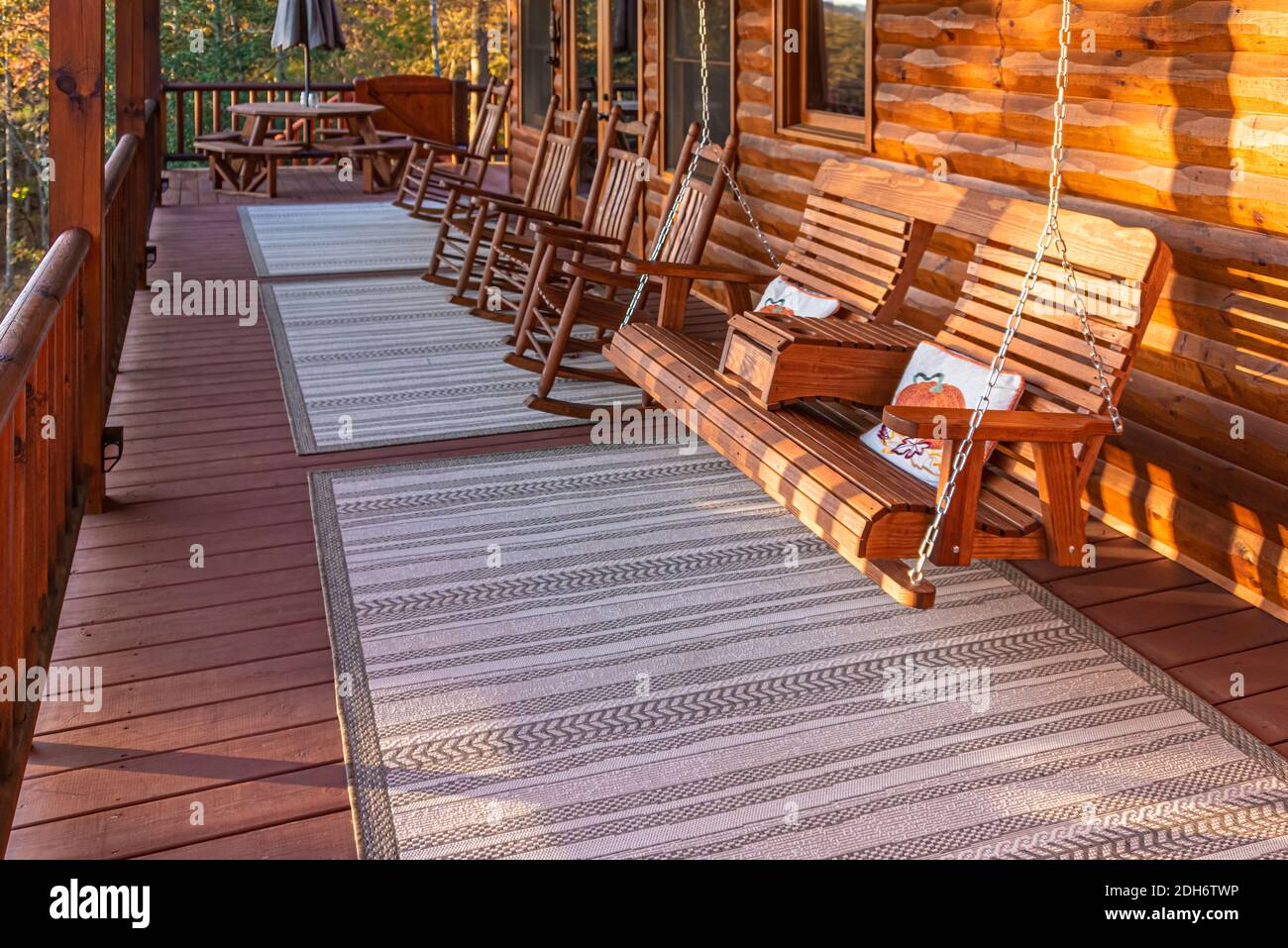 Les rockers sur le pont et la balançoire du porche offrent une vue magnifique sur le lever du soleil d'automne depuis cette cabane en rondins de luxe en bord de lac dans les Blue Ridge Mountains de Géorgie. (ÉTATS-UNIS) Banque D'Images