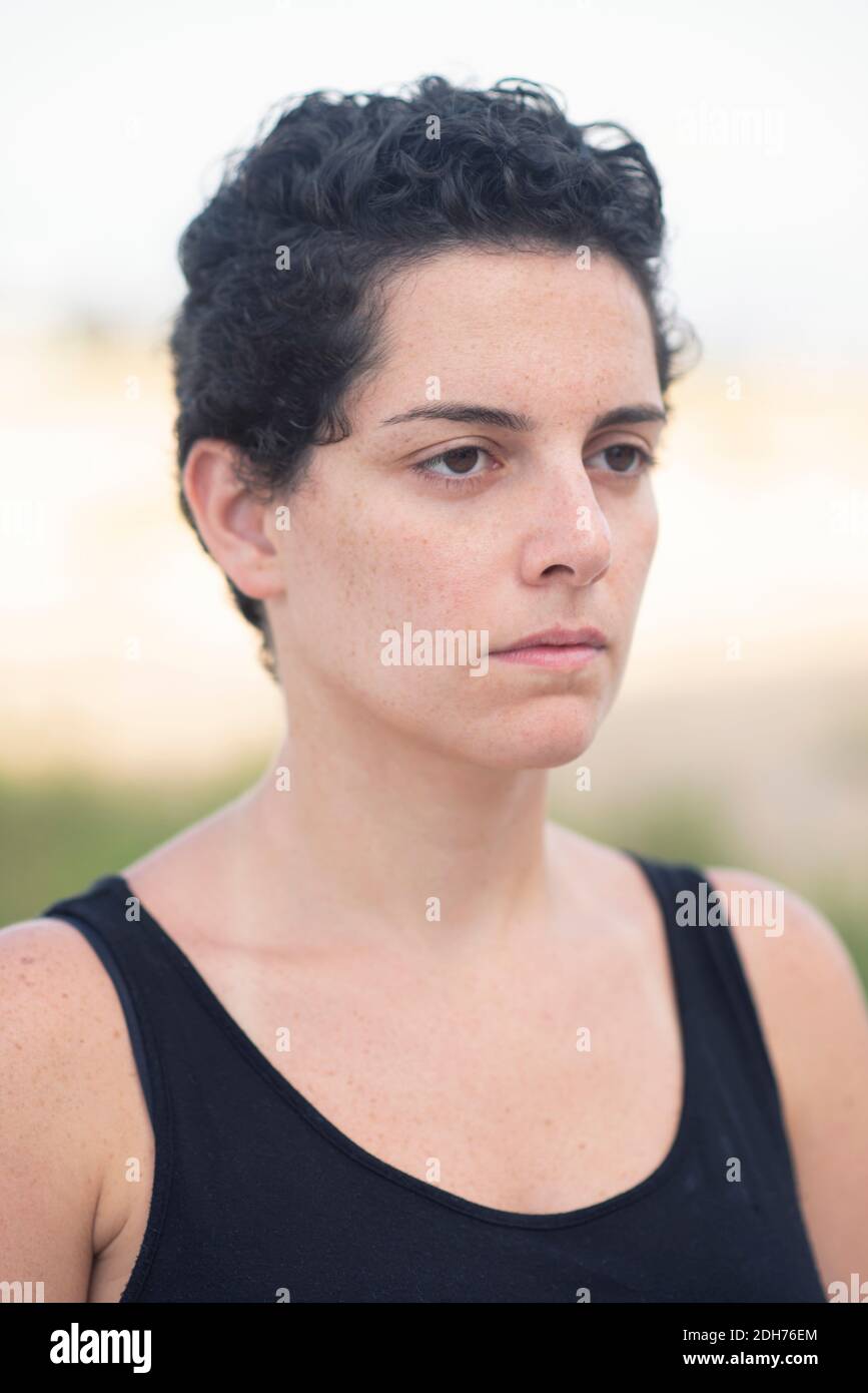 Belle jeune femme avec des cheveux courts regardant loin à l'extérieur Banque D'Images