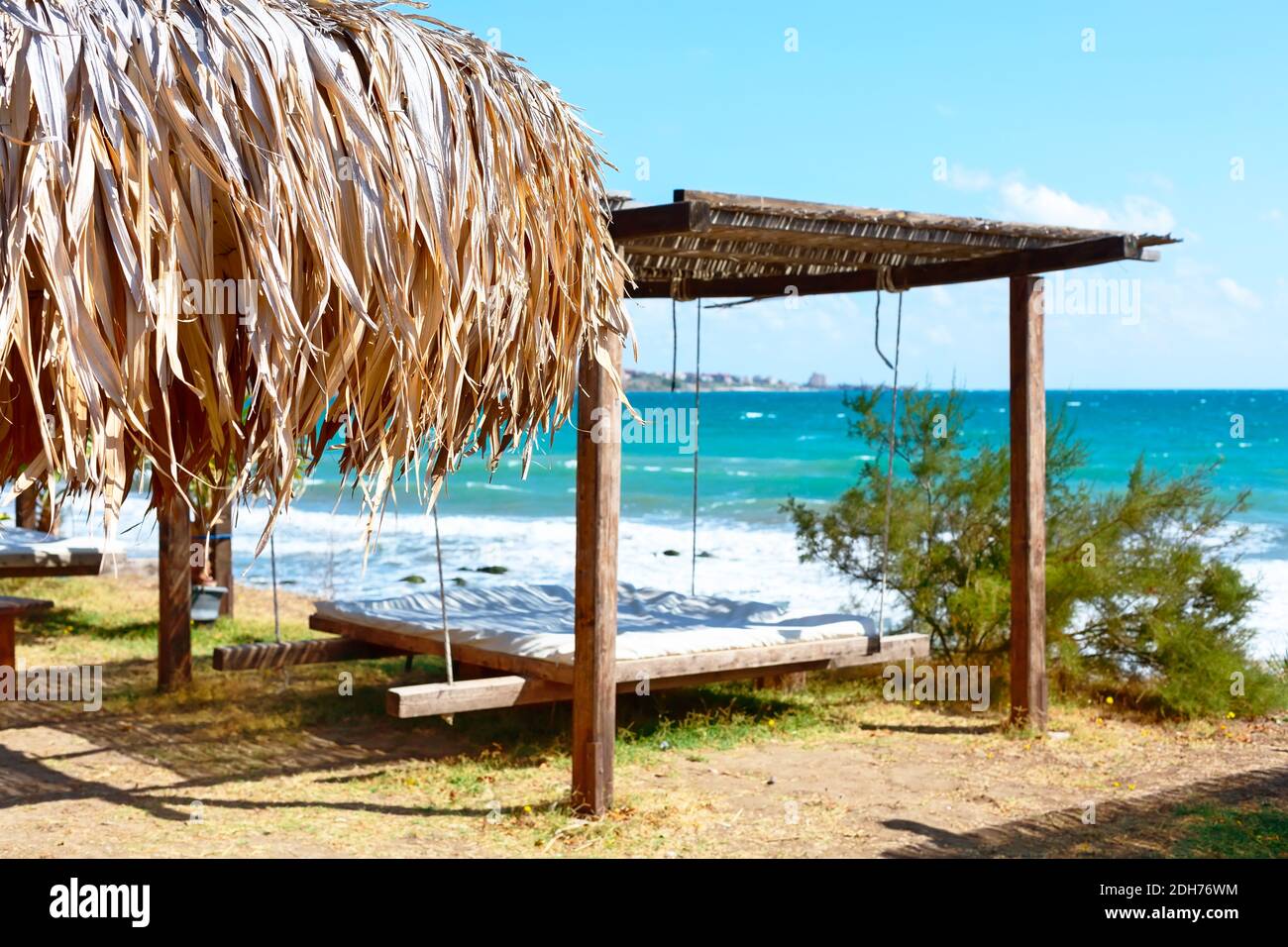 Parasol et lit de plage avec salon, mer et ciel bleu Banque D'Images
