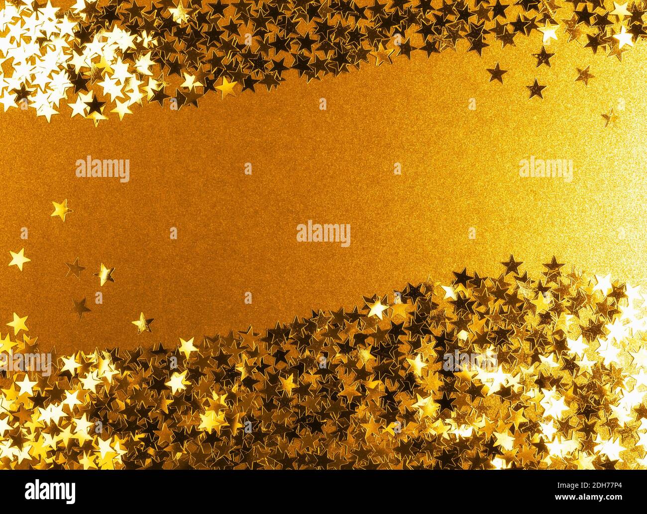 Fond doré avec étoiles confettis brillantes. Toile de fond festive. Arrière-plan de Noël. Composition créative et carte de vœux Banque D'Images