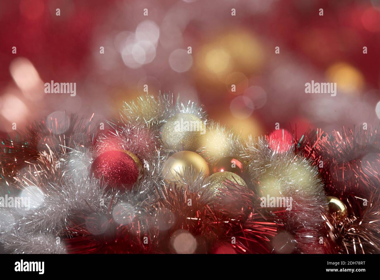 Boules rouges et dorées sur fond flou et étincelant, lumières de bokeh. Nouvel an d'or 2021. Carte de joyeux Noël. Banque D'Images
