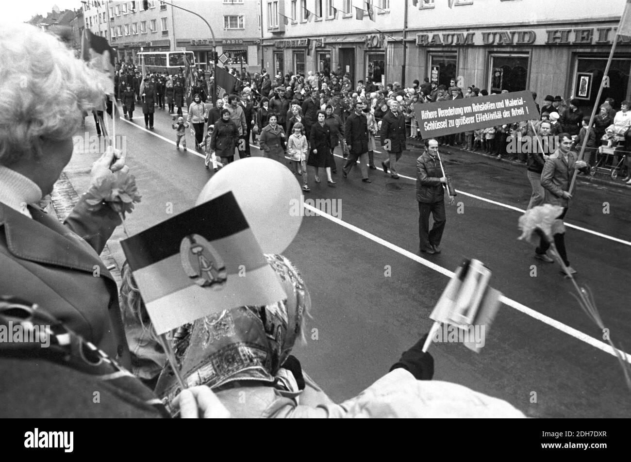 01 mai 1982, Saxe, Eilenburg: 'Amélioration du raffinement des matières premières et des matières premières - la clé pour un travail plus efficace!'. Lors de la manifestation à Eilenburg, le 1er mai 1982, des ouvriers, des écoliers, des sportifs et des enfants défilent devant l'hôtel de ville et une tribune avec des invités d'honneur s'y est installé. Photo: Volkmar Heinz/dpa-Zentralbild/ZB Banque D'Images