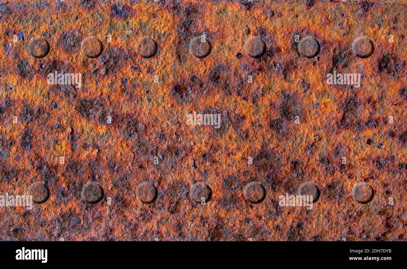 Ancienne tôle de métal rouillée avec deux rangées de rivets gros plan, texture métallique ou arrière-plan Banque D'Images