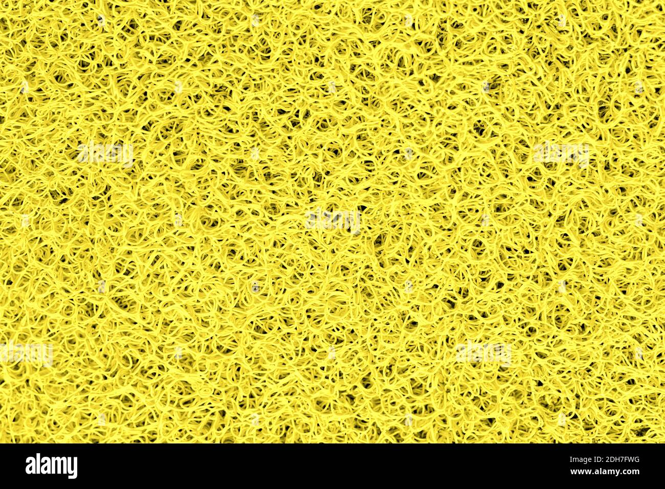 Détail en gros plan illuminant la texture du tapis de porte en plastique de couleur jaune. Surface de toile de fond neutre et abstraite. Couleur de l'année 2021 Banque D'Images