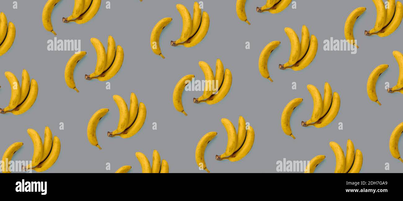Bananes jaunes sur fond gris, texture. Concept d'été, pose plate. Couleurs tendance du 2021 Banque D'Images