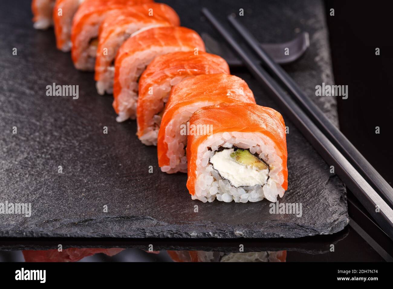 De magnifiques rouleaux de Philadelphie avec du saumon et du fromage à la  crème sur une assiette d'ardoise noire. Surama Uramaki, Nori Maki ou  Futomaki avec wasabi Photo Stock - Alamy