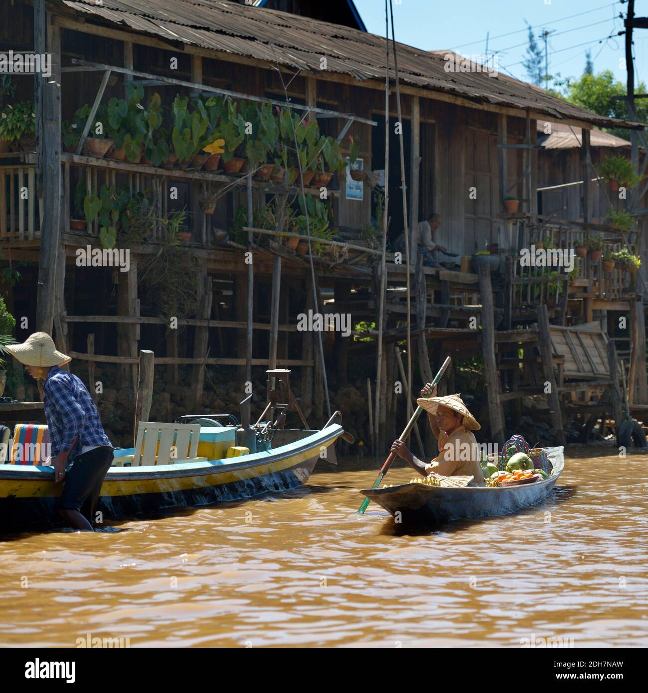 LAC INLE, MYANMAR - 27 FÉVRIER 2015 : homme birman vendant des fruits dans son bateau en bois. Ce type de transport est typique pour le lac Inle, Myanmar. Banque D'Images