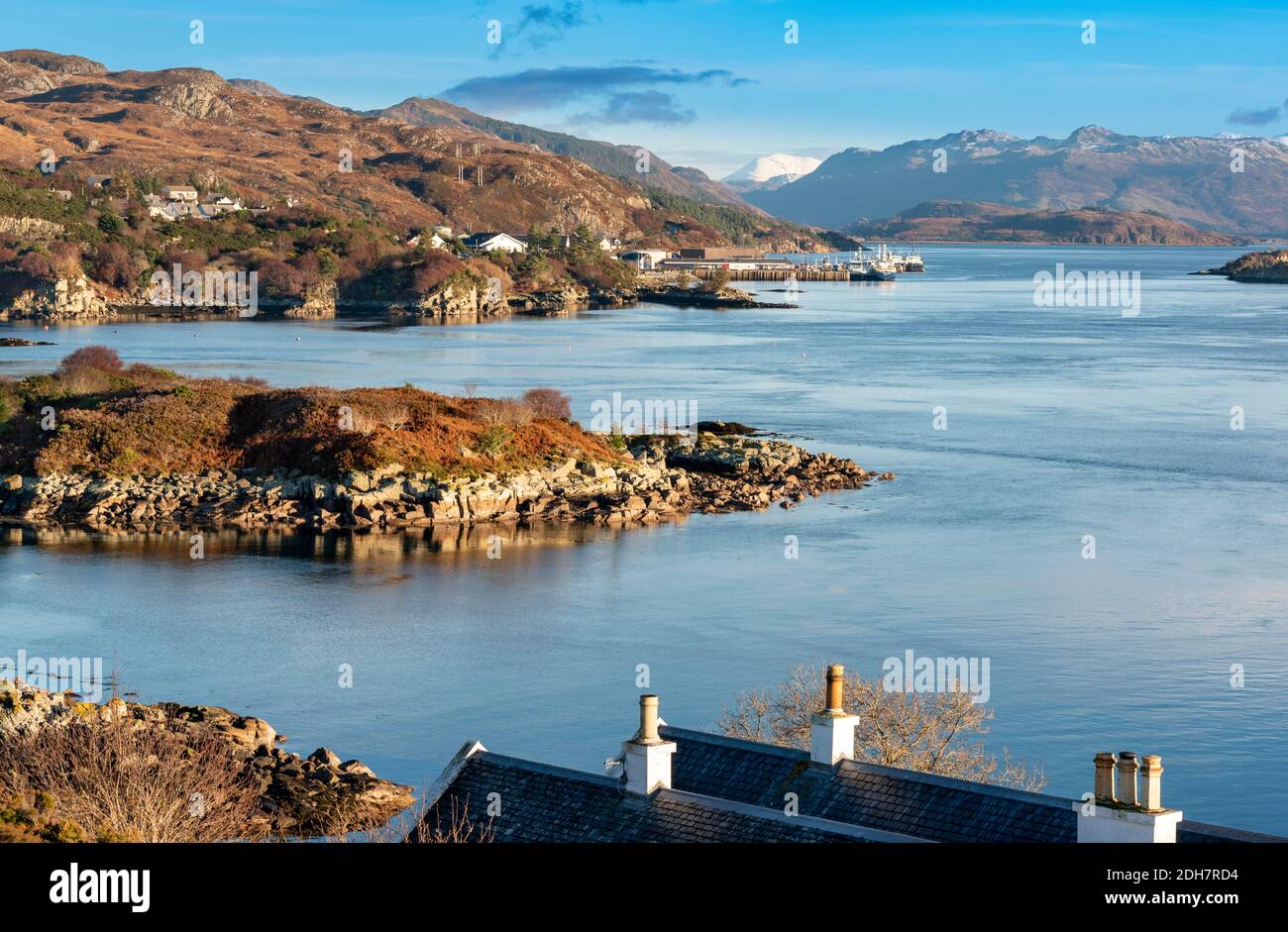 KYLE DE LOCHALSH ROSS-SHIRE ÉCOSSE LITTORAL SAUVAGE AVEC BATEAUX DE PÊCHE AMARRÉ LE LONG DE LA RIVE DU LOCH ALSH NEIGE SUR LE COLLINES Banque D'Images
