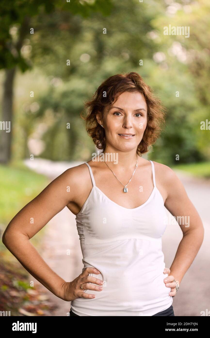 Portrait de la femme en forme debout avec les mains sur les hanches à stationnement Banque D'Images