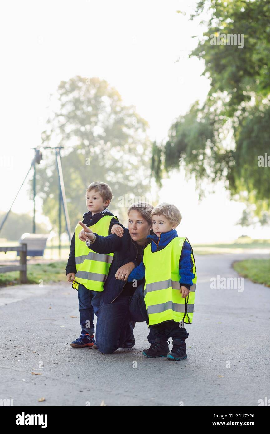 Professeur montrant quelque chose aux enfants tout en pointant vers l'aire de jeux Banque D'Images