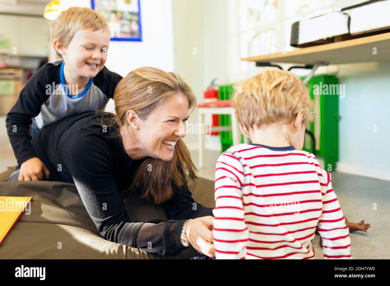 Joyeux enseignant jouant avec les enfants de la maternelle Banque D'Images