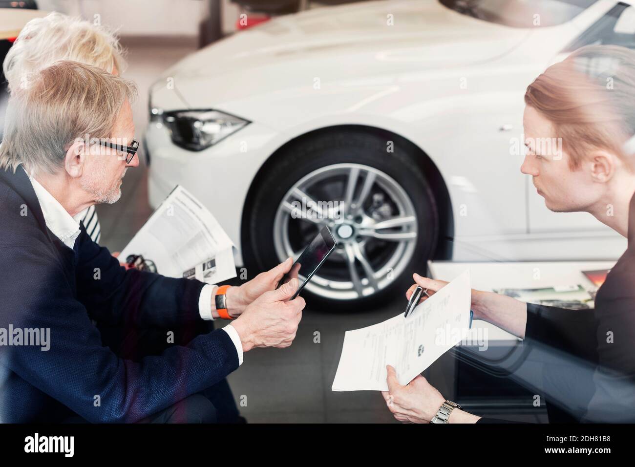 Le vendeur s'est montré d'accord avec le couple senior de la concession automobile Banque D'Images