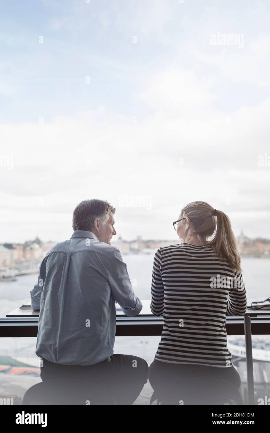 Les gens d'affaires assis au comptoir près de la fenêtre dans le bureau Banque D'Images