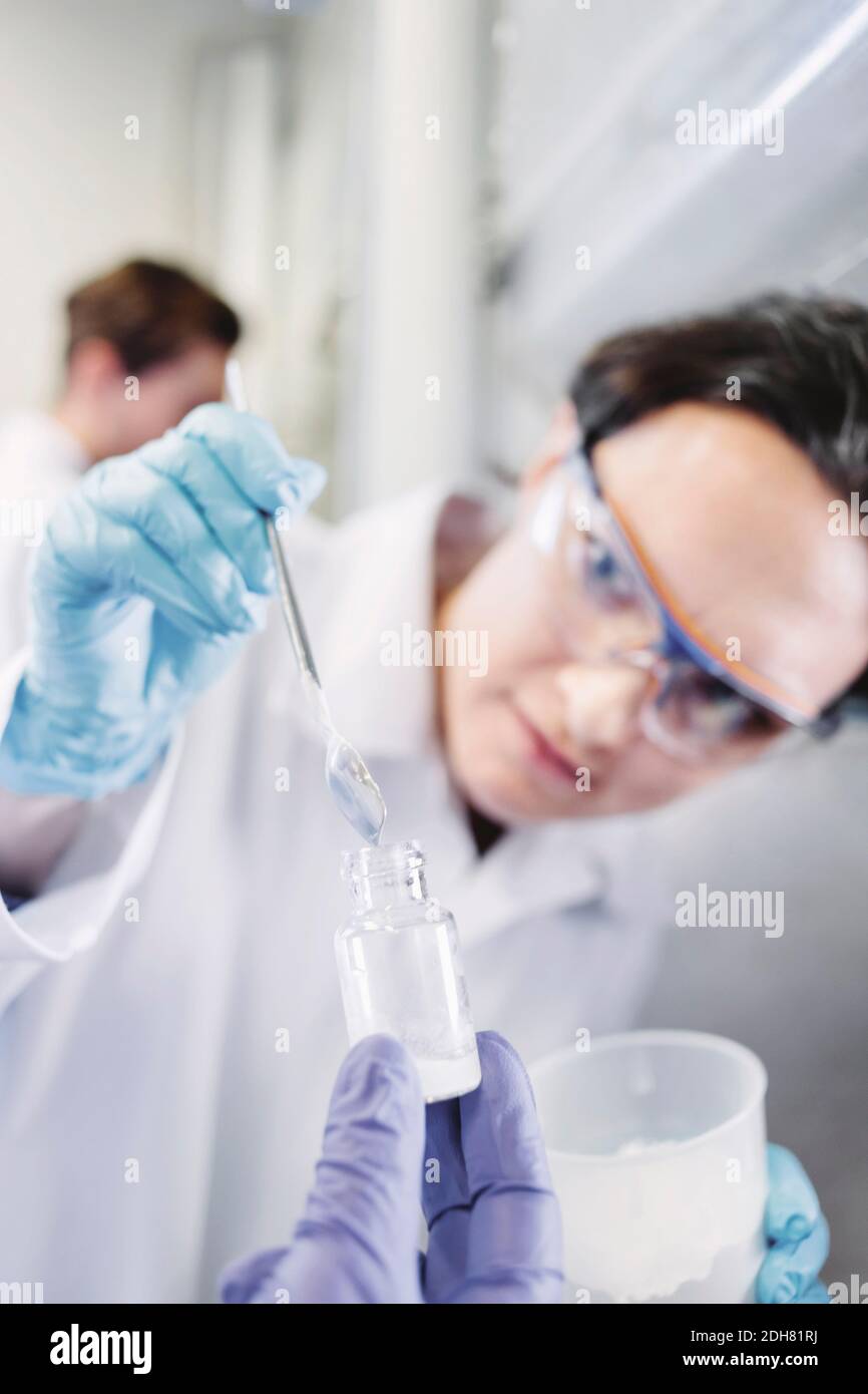 Scientifique féminin utilisant une pipette pour examiner l'échantillon en laboratoire Banque D'Images