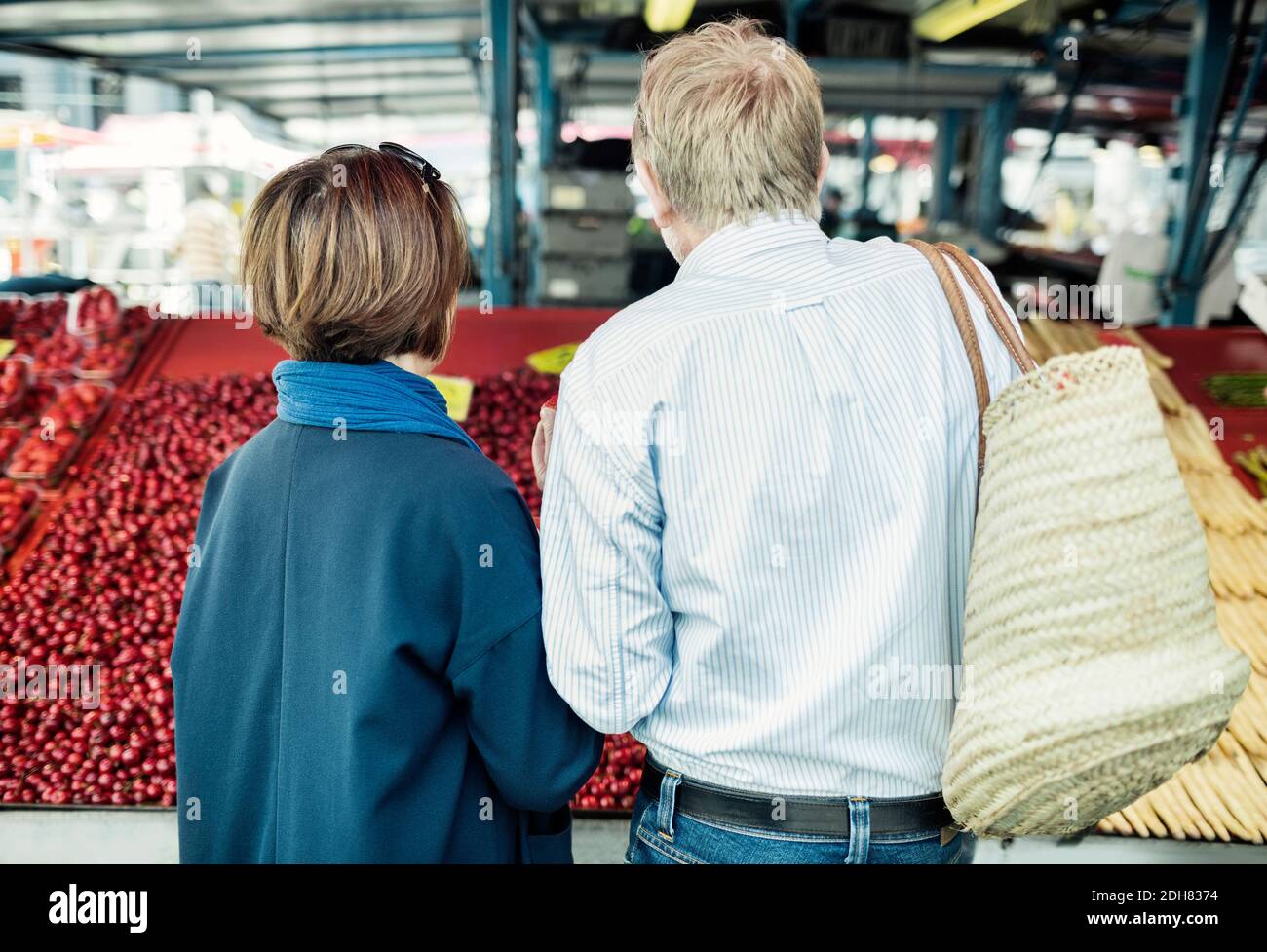 Vue arrière du couple senior achetant des fruits au marché Banque D'Images