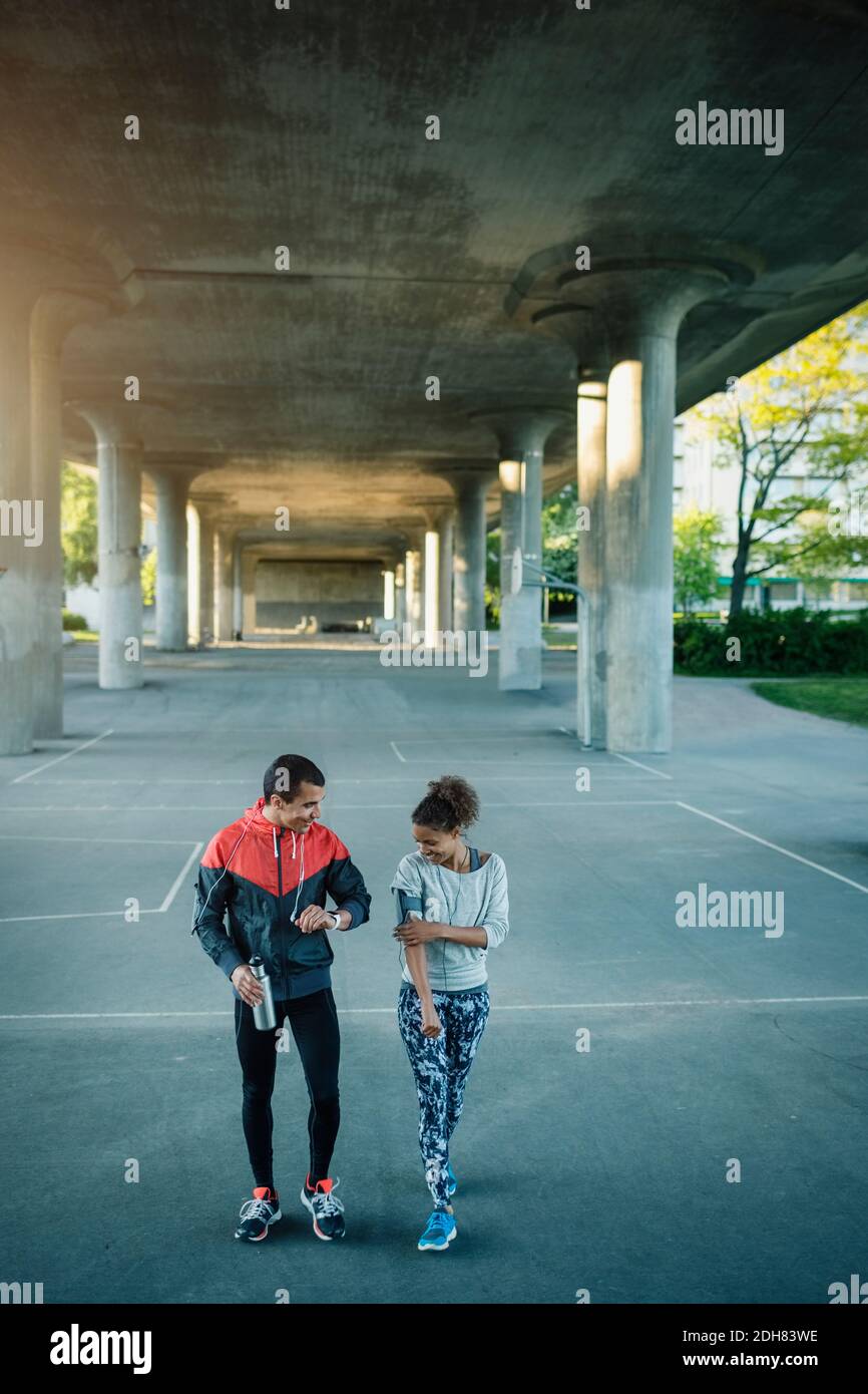 Des amis heureux marchant dans la rue sous le pont Banque D'Images