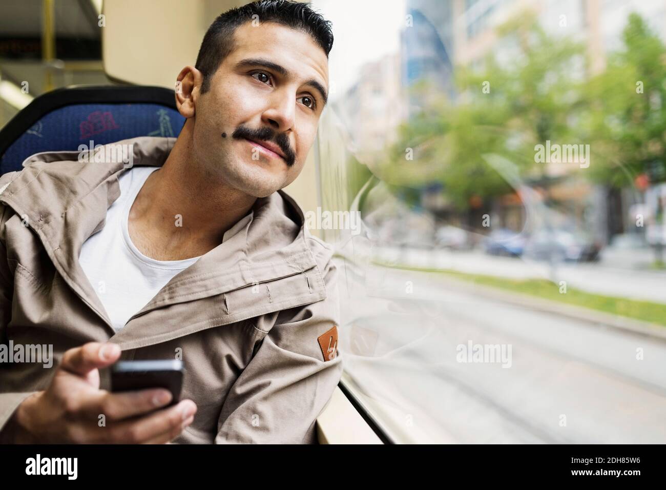 Jeune homme regardant à travers la fenêtre de tram Banque D'Images