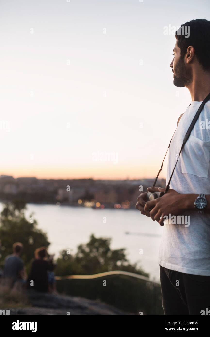 Mâle touriste regardant la vue tout en se tenant contre le ciel clair Banque D'Images