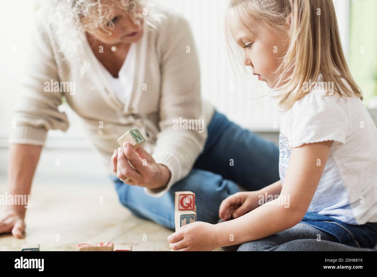 Enseignante montrant bloc à fille dans la garderie Banque D'Images