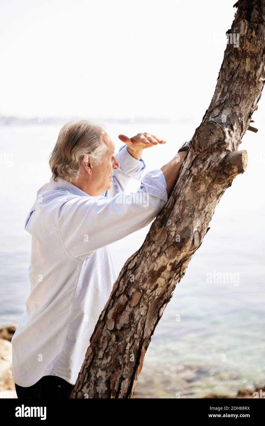 Homme senior qui protège les yeux tout en regardant la vue Banque D'Images