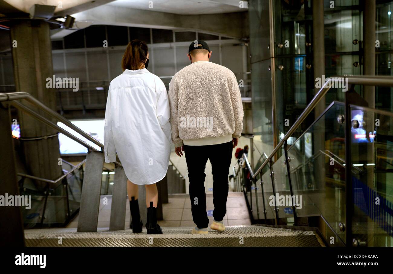 Londres, Angleterre, Royaume-Uni. Couple à la station de métro de Westminster - la femme ne porte apparemment rien d'autre qu'une longue chemise Banque D'Images