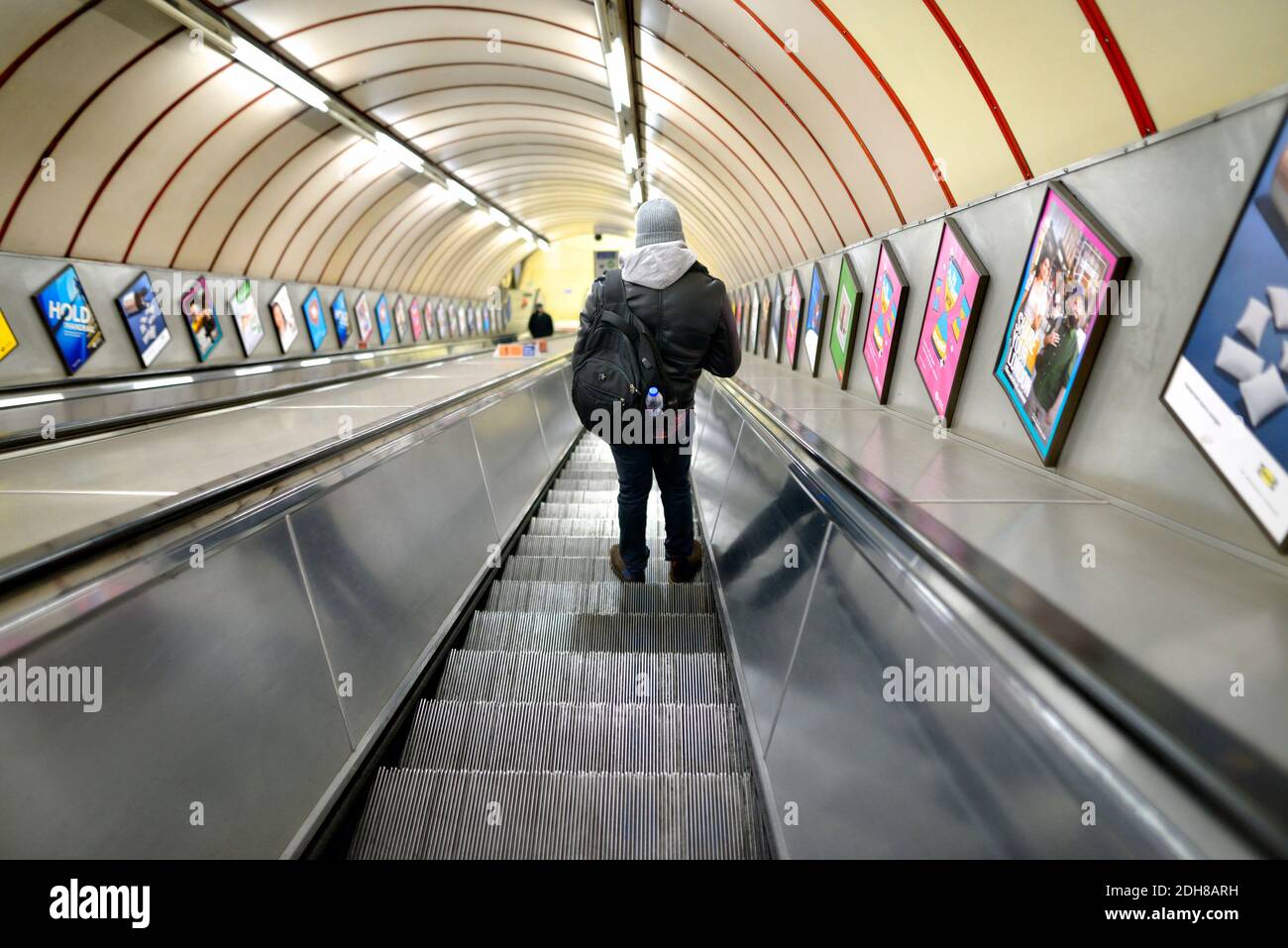 Londres, Angleterre, Royaume-Uni. Homme sur un escalier roulant dans une station de métro Banque D'Images