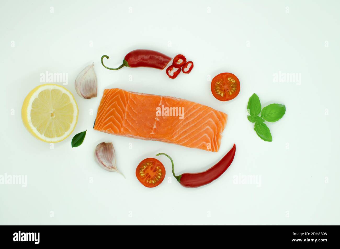 Morceau de saumon isolé sur blanc, ail, piment rouge citron, tomate Banque D'Images
