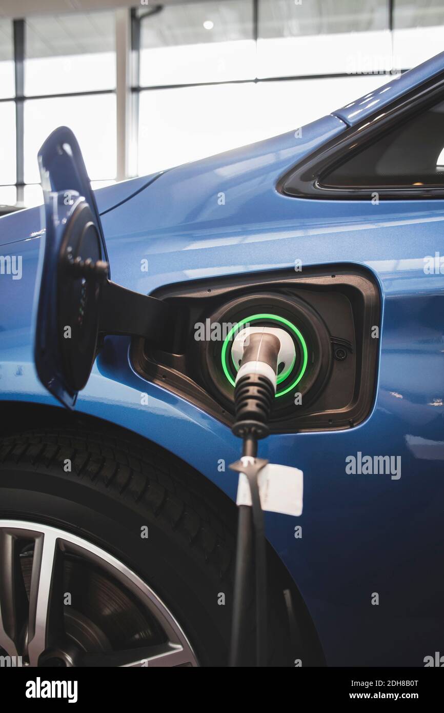 Chargeur de batterie dans une voiture électrique bleue à la salle d'exposition Banque D'Images