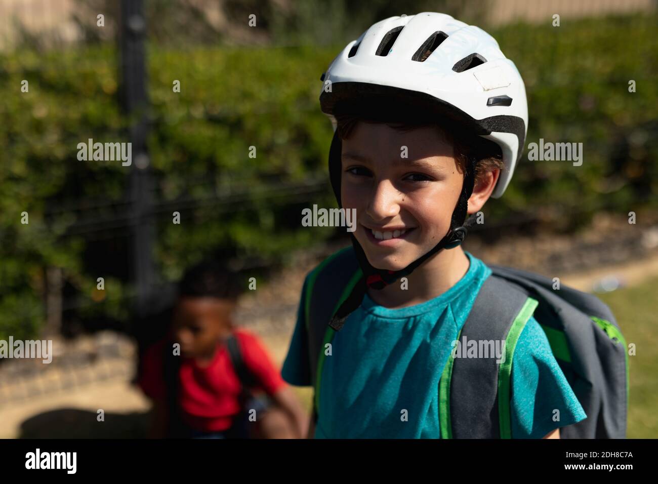 Un écolier porte un casque de cyclisme et fait du vélo Banque D'Images
