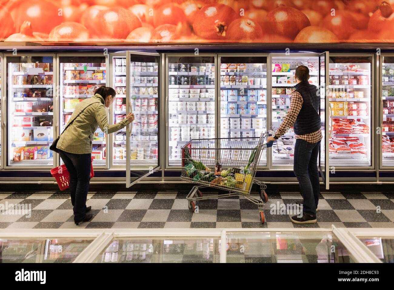 Couple choisissant à la section réfrigérée dans le supermarché Banque D'Images