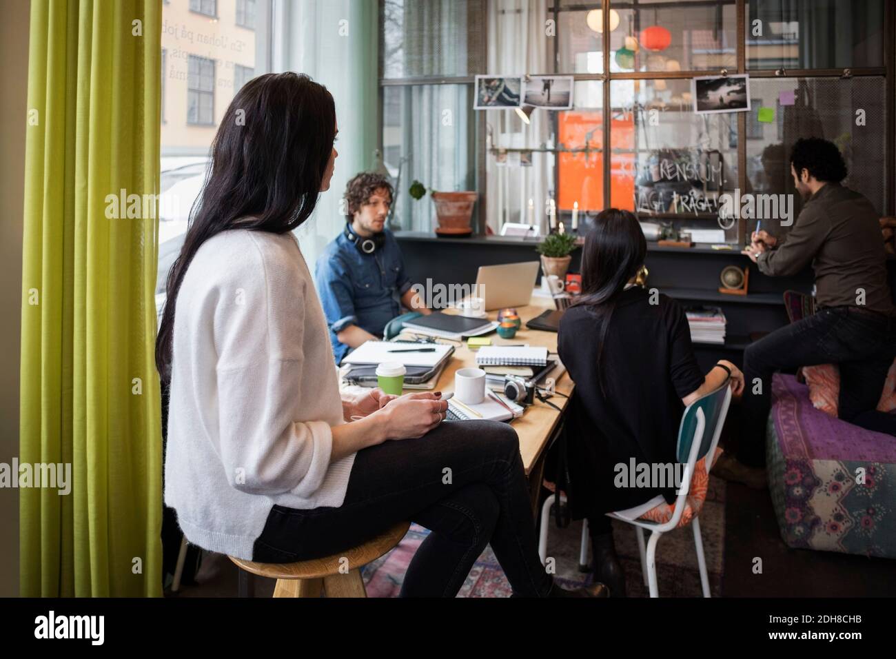 Équipe créative regardant l'homme écrire dans une note adhésive à bureau moderne Banque D'Images