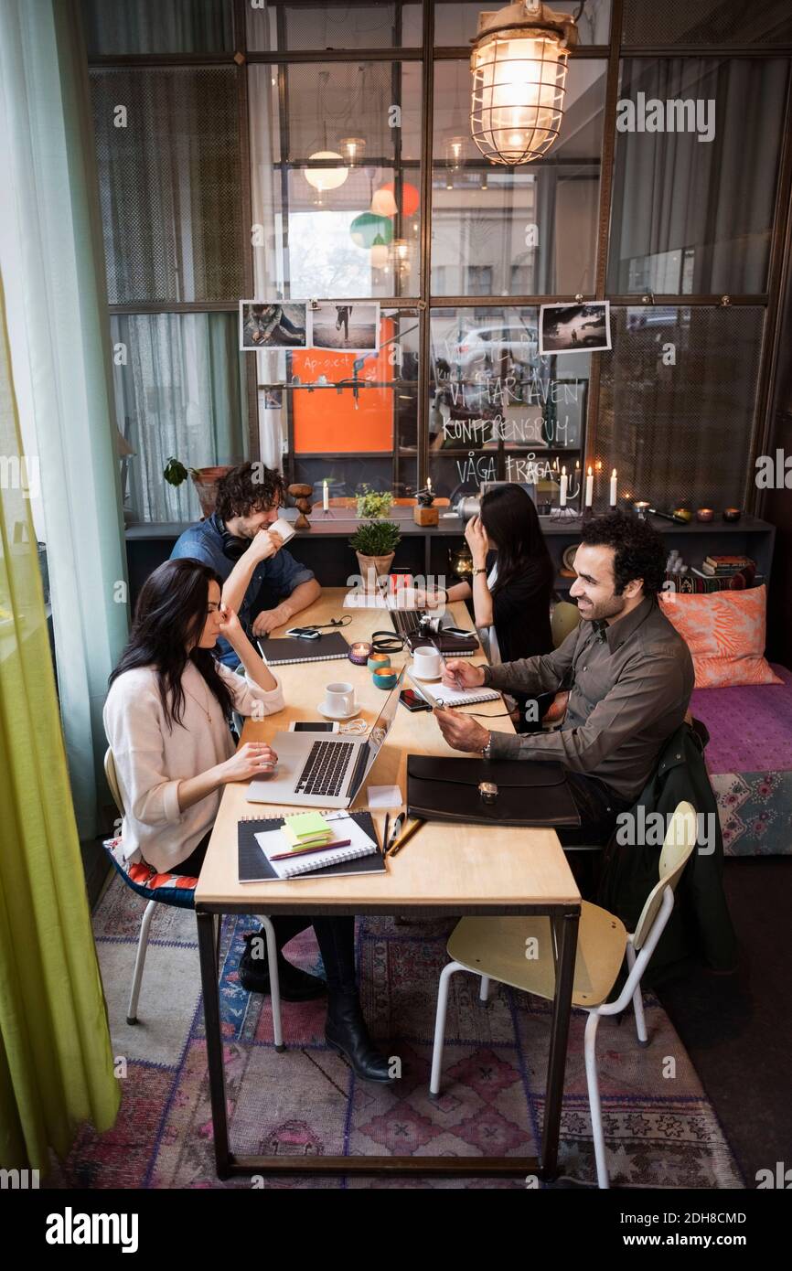 Vue en grand angle de l'équipe créative travaillant à table dans un bureau moderne Banque D'Images