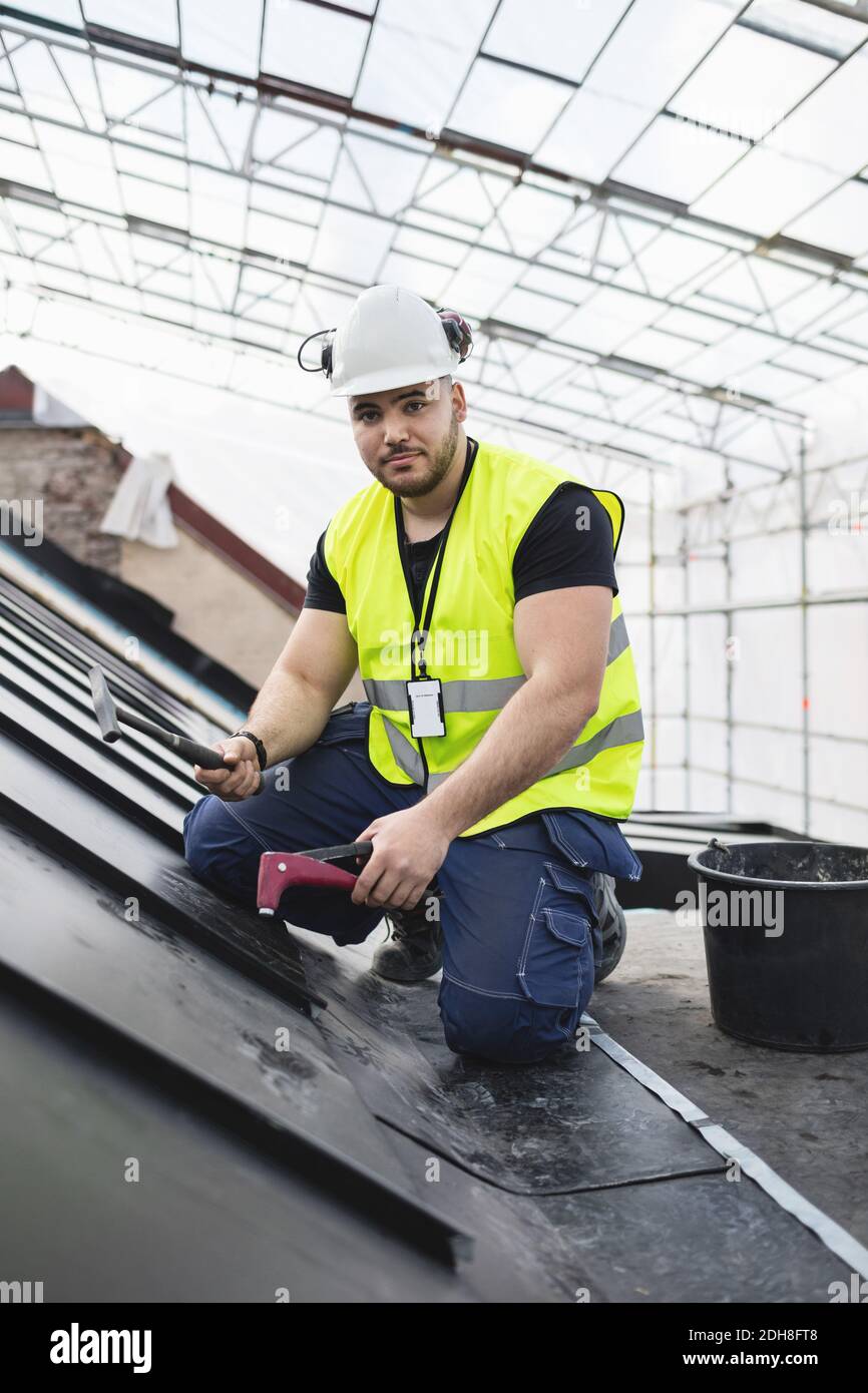 Portrait d'un travailleur manuel travaillant avec des outils sur du métal à chantier Banque D'Images