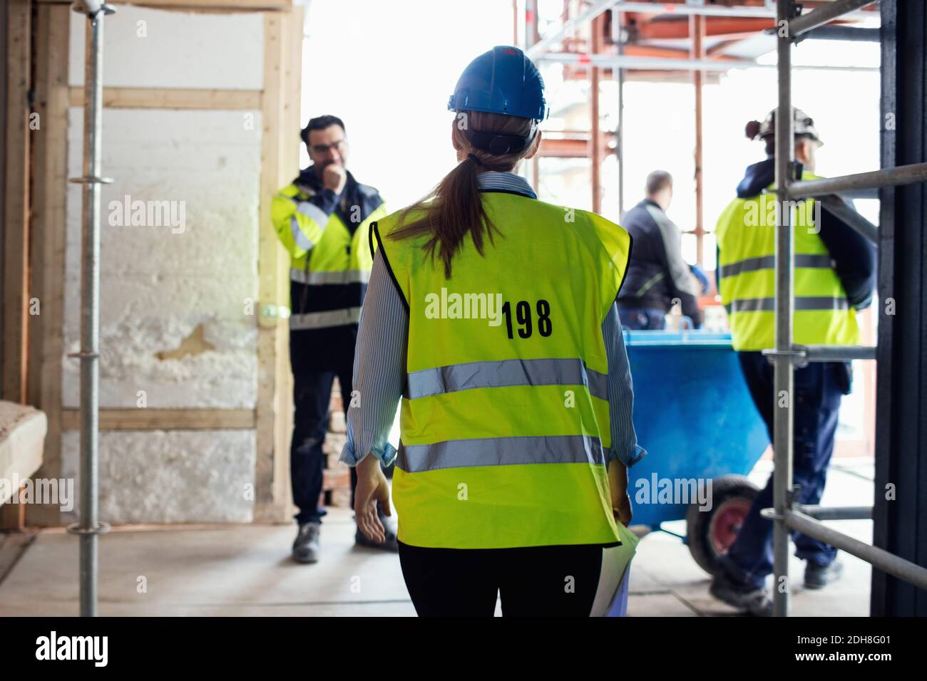 Les travailleurs manuels discutent lorsqu'ils se tiennent sur le chantier Banque D'Images