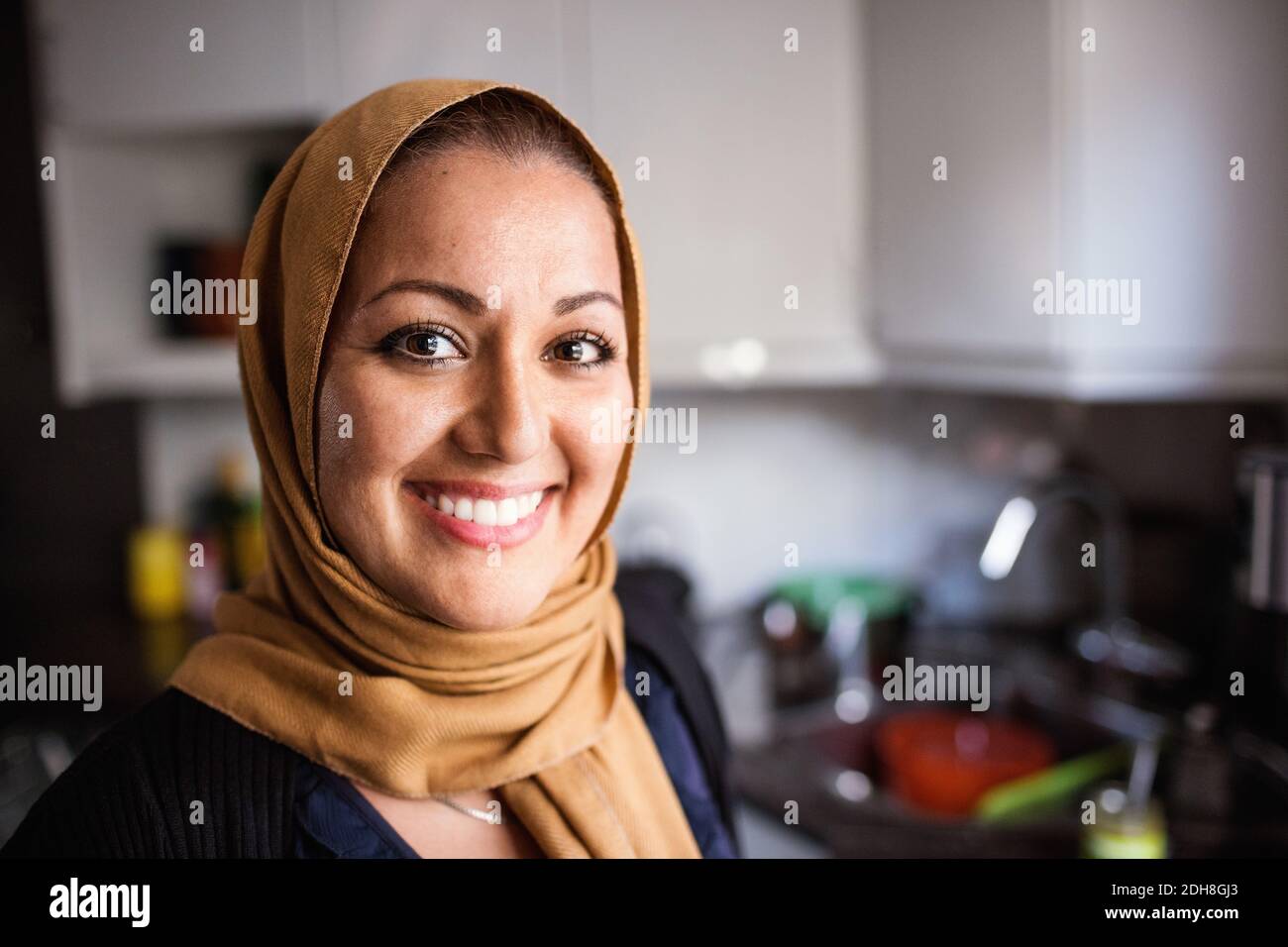 Portrait d'une femme heureuse dans la cuisine à la maison Banque D'Images