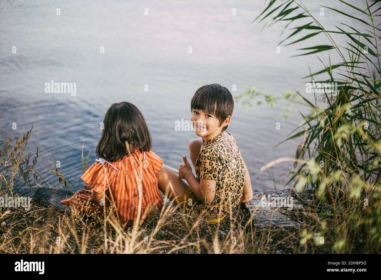 Portrait de fille souriante avec le syndrome de Down sœur assis près lac Banque D'Images