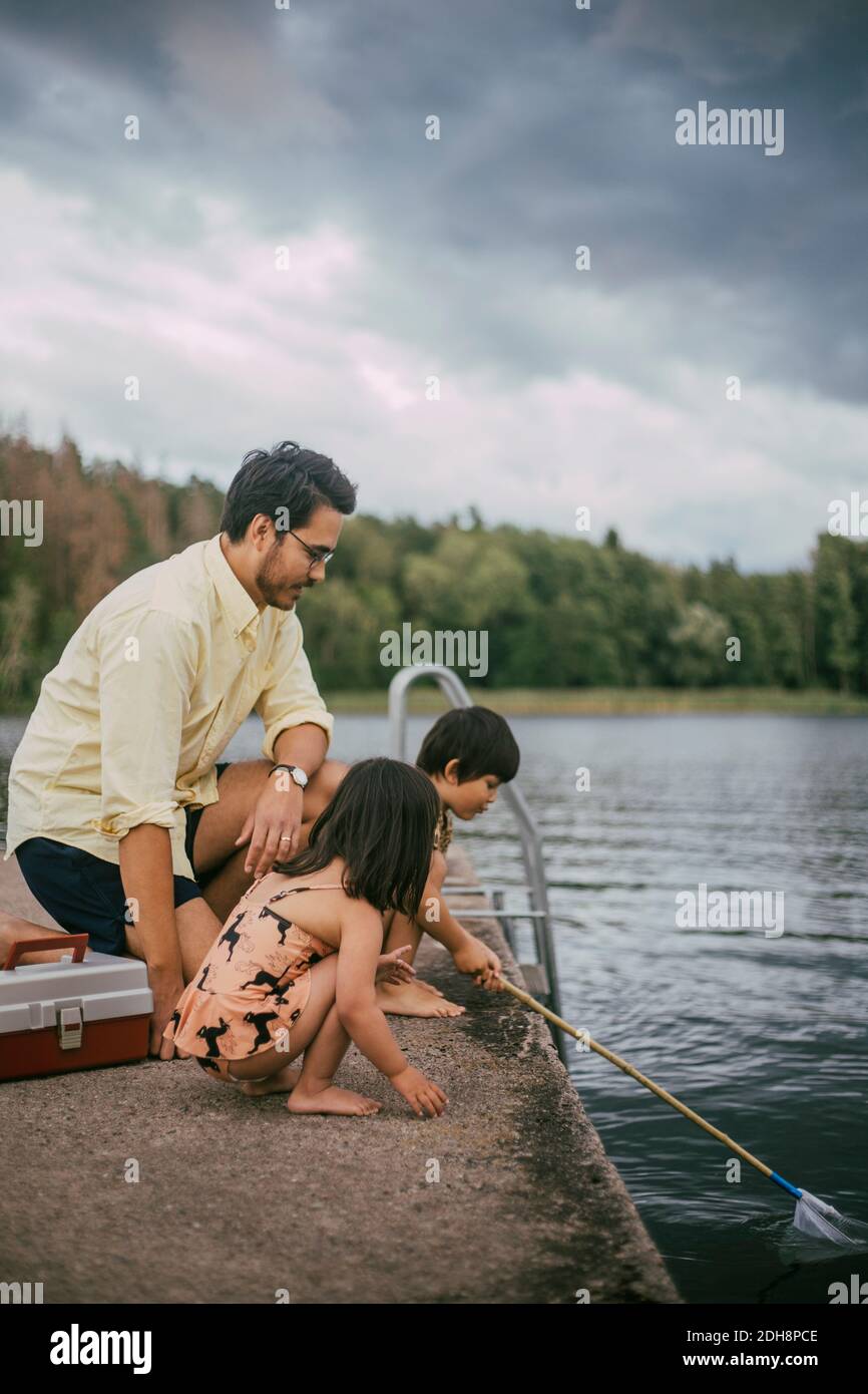 Père avec des filles pêchant pendant l'été Banque D'Images