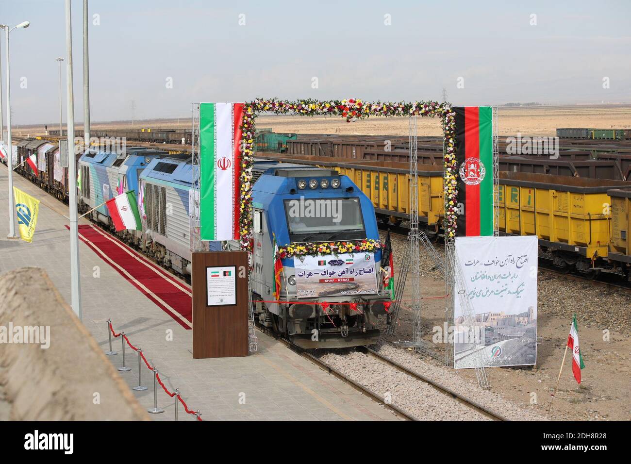 Téhéran, Iran. 10 décembre 2020. Un train se prépare à déménager lors de l'inauguration d'une ligne de 140 kilomètres (90 milles) reliant l'est de l'Iran à l'ouest de l'Afghanistan, à une gare de Khaf, en Iran, le jeudi 10 décembre 2020. Les dirigeants de l'Iran et de l'Afghanistan ont inauguré jeudi la première liaison ferroviaire entre les deux pays, exprimant l'espoir qu'elle accroîtra les liens commerciaux dans toute la région. Les panneaux en persan offrent des félicitations au peuple iranien et afghan pour l'inauguration du chemin de fer Khaf-Herat. Credit: Présidence iranienne/ZUMA Wire/Alamy Live News Banque D'Images