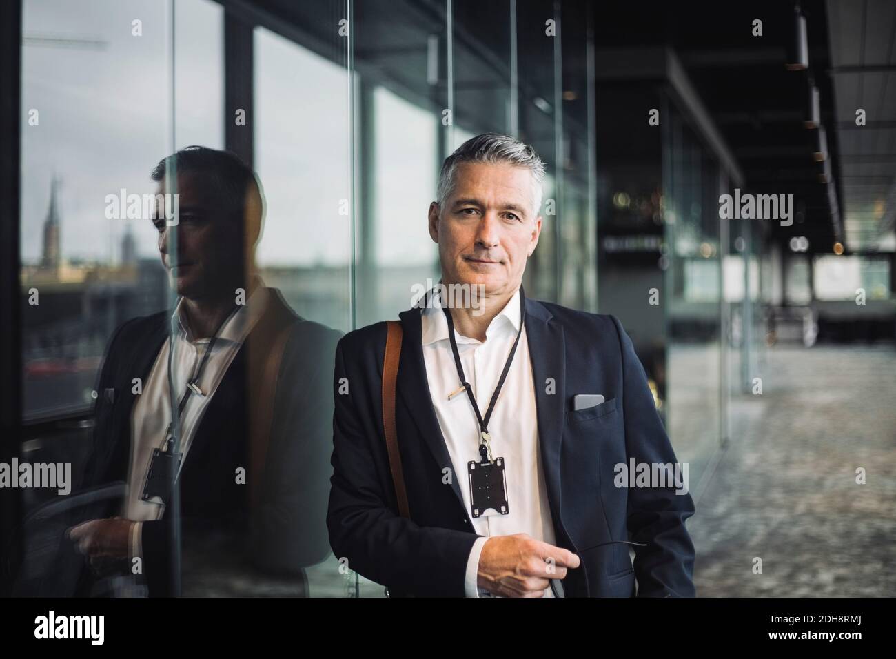 Portrait de l'entrepreneur penché sur la fenêtre en verre dans le bureau Banque D'Images