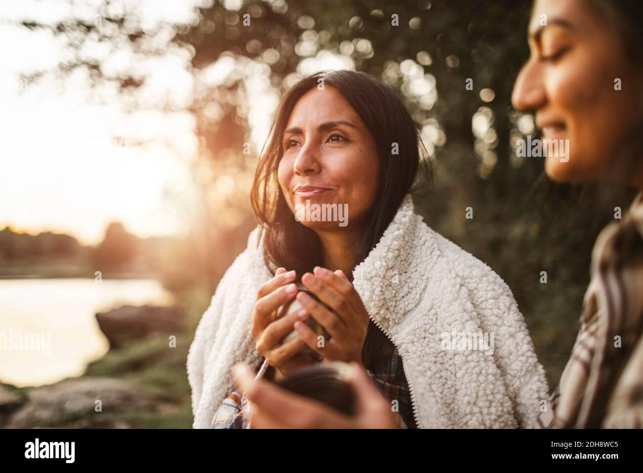 Des amies qui parlent tout en buvant du café dans la forêt Banque D'Images