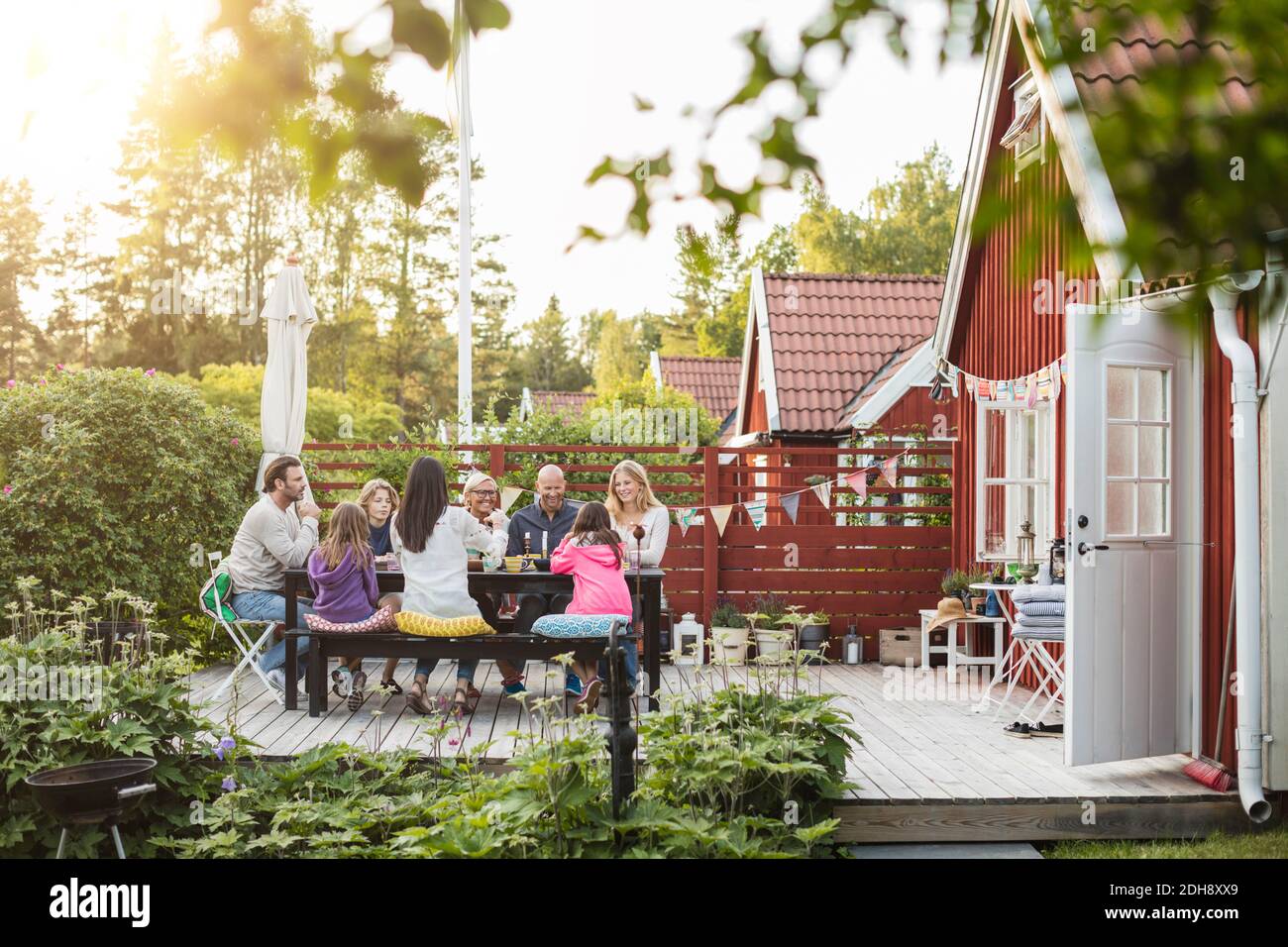 Une famille heureuse et des amis qui mangent dans le jardin pour le déjeuner arrière-cour Banque D'Images