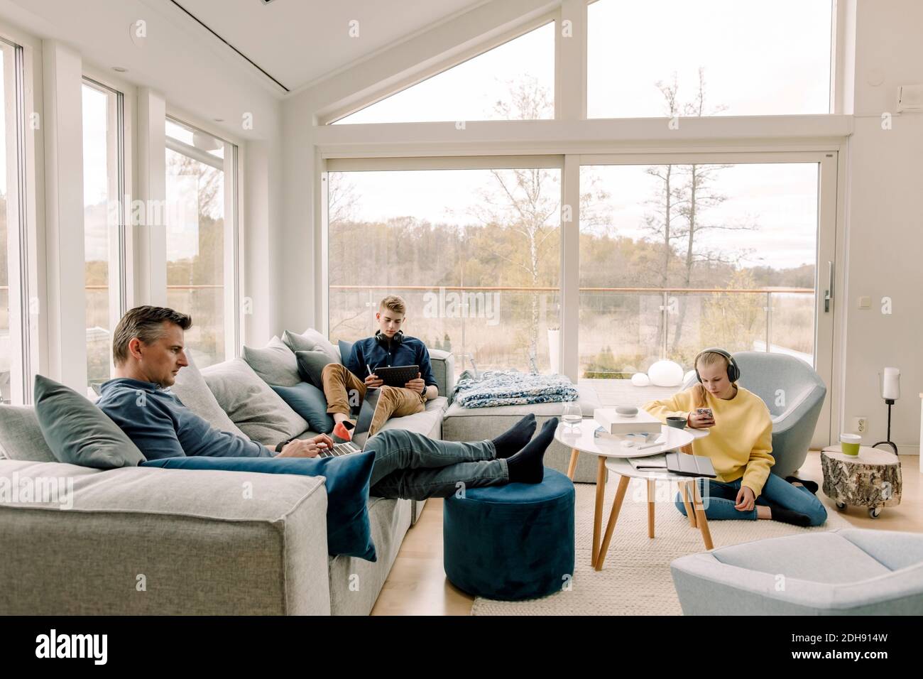 Père et enfants utilisant la technologie sans fil à la maison Banque D'Images