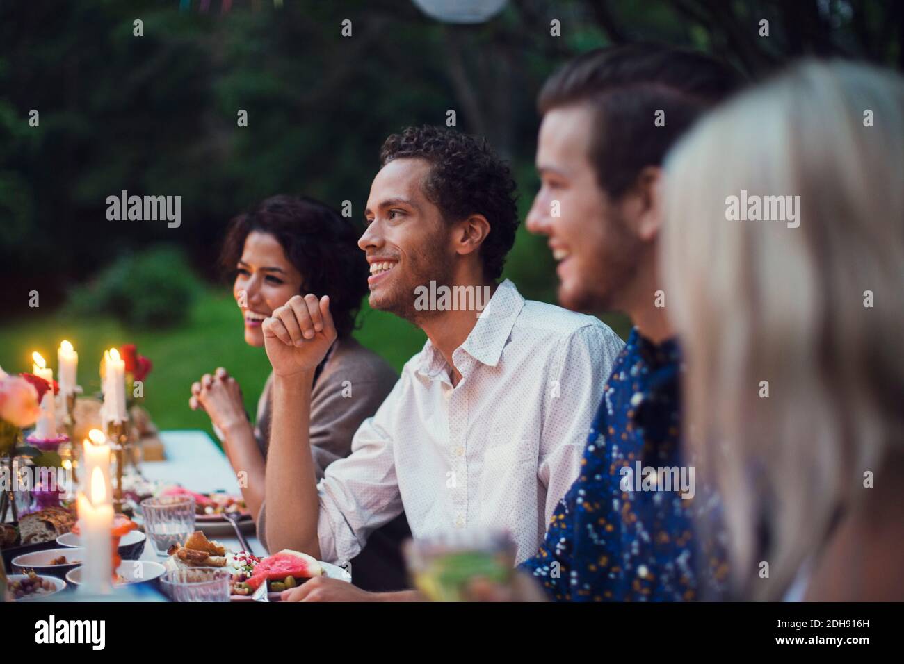 Des amis heureux qui dîne à table pendant la fête dans le jardin Banque D'Images