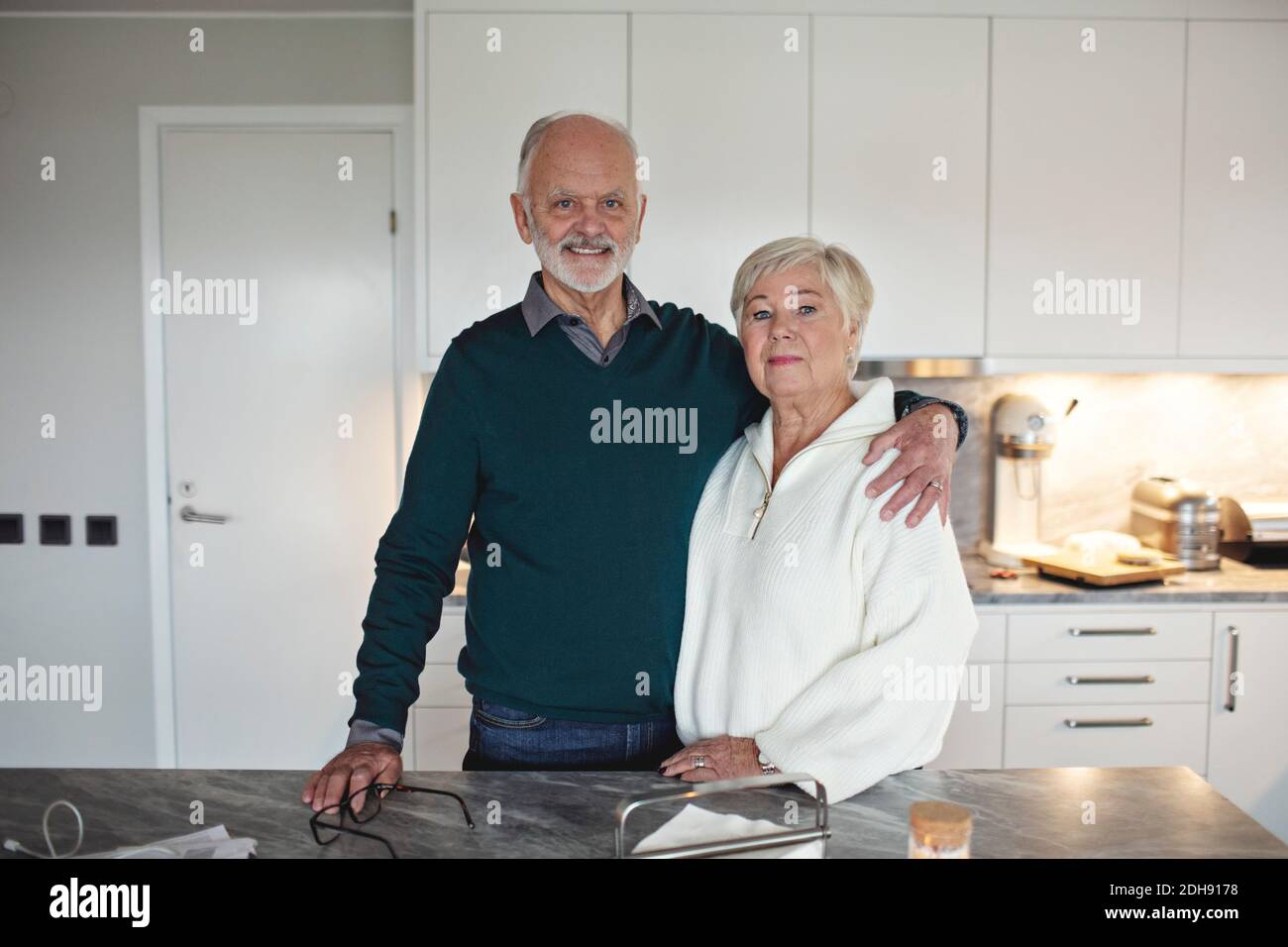 Portrait d'un couple senior debout près d'une cuisine insulaire à la maison Banque D'Images