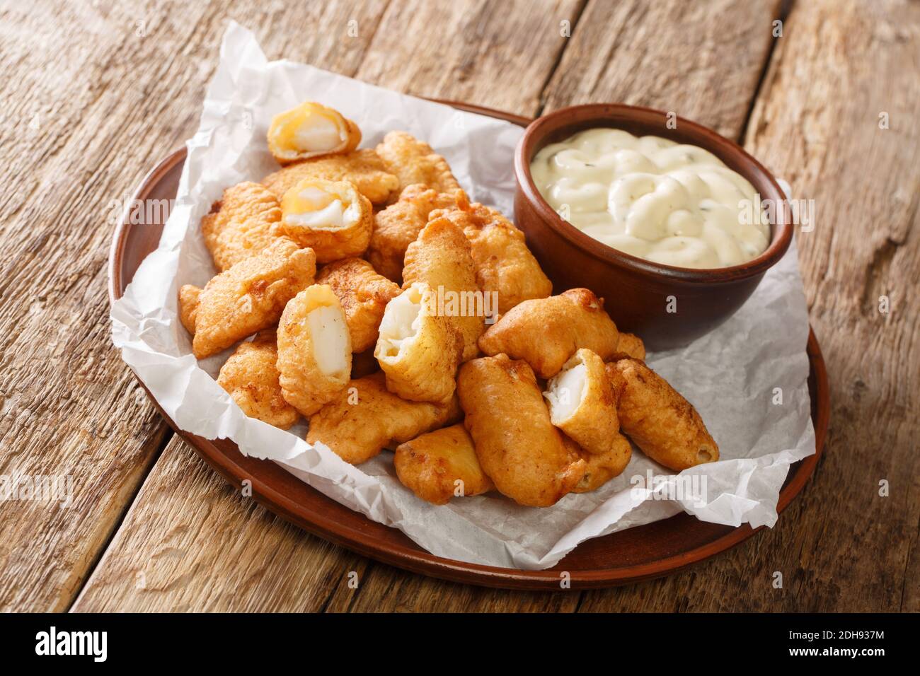 Le célèbre aliment de rue hollandais Kibbeling se compose de morceaux de poisson de morue qui sont trempés dans la pâte, frits et servis avec une sauce à tremper près Banque D'Images