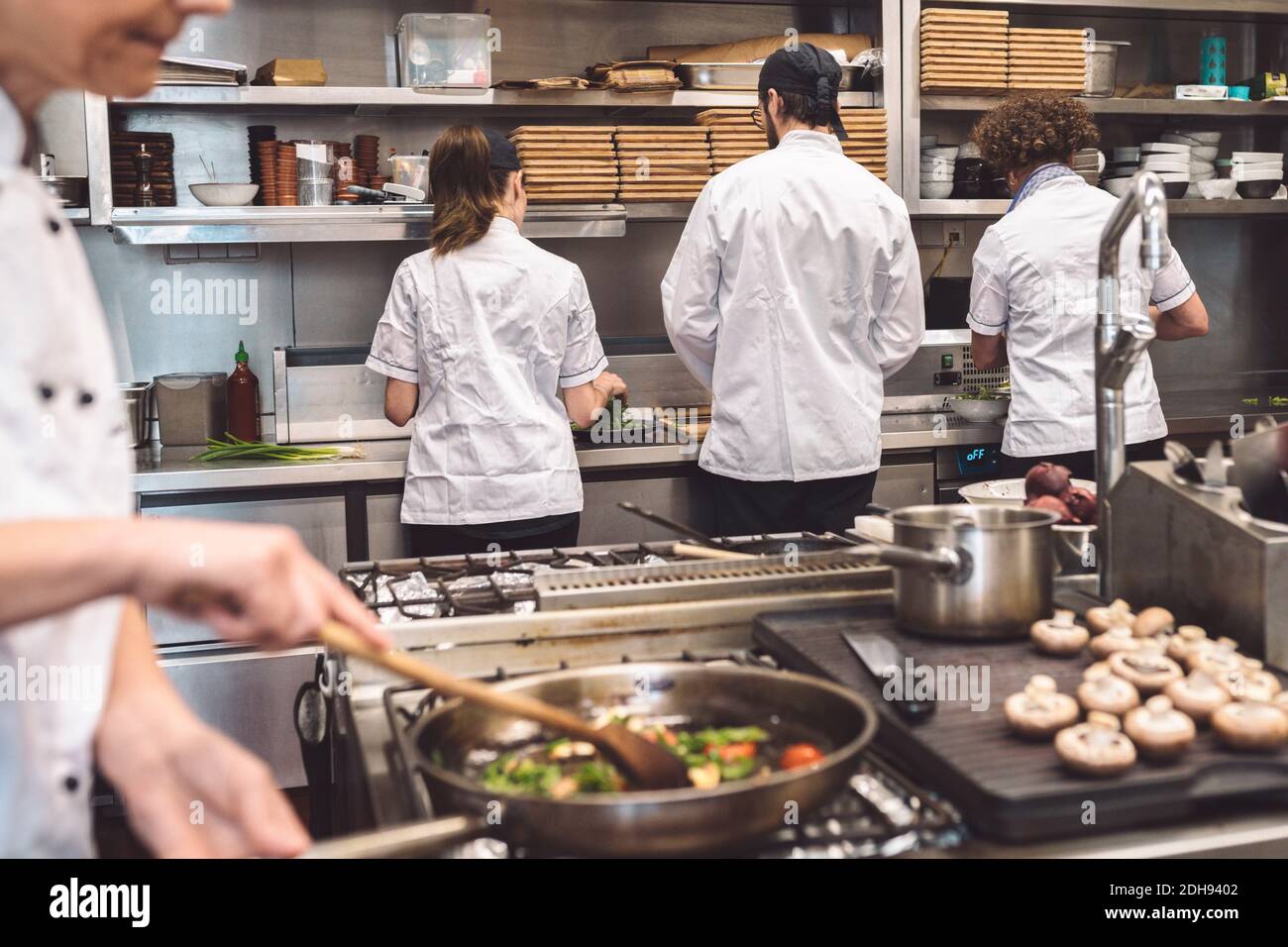 Section intermédiaire du chef préparant la nourriture au restaurant Banque D'Images